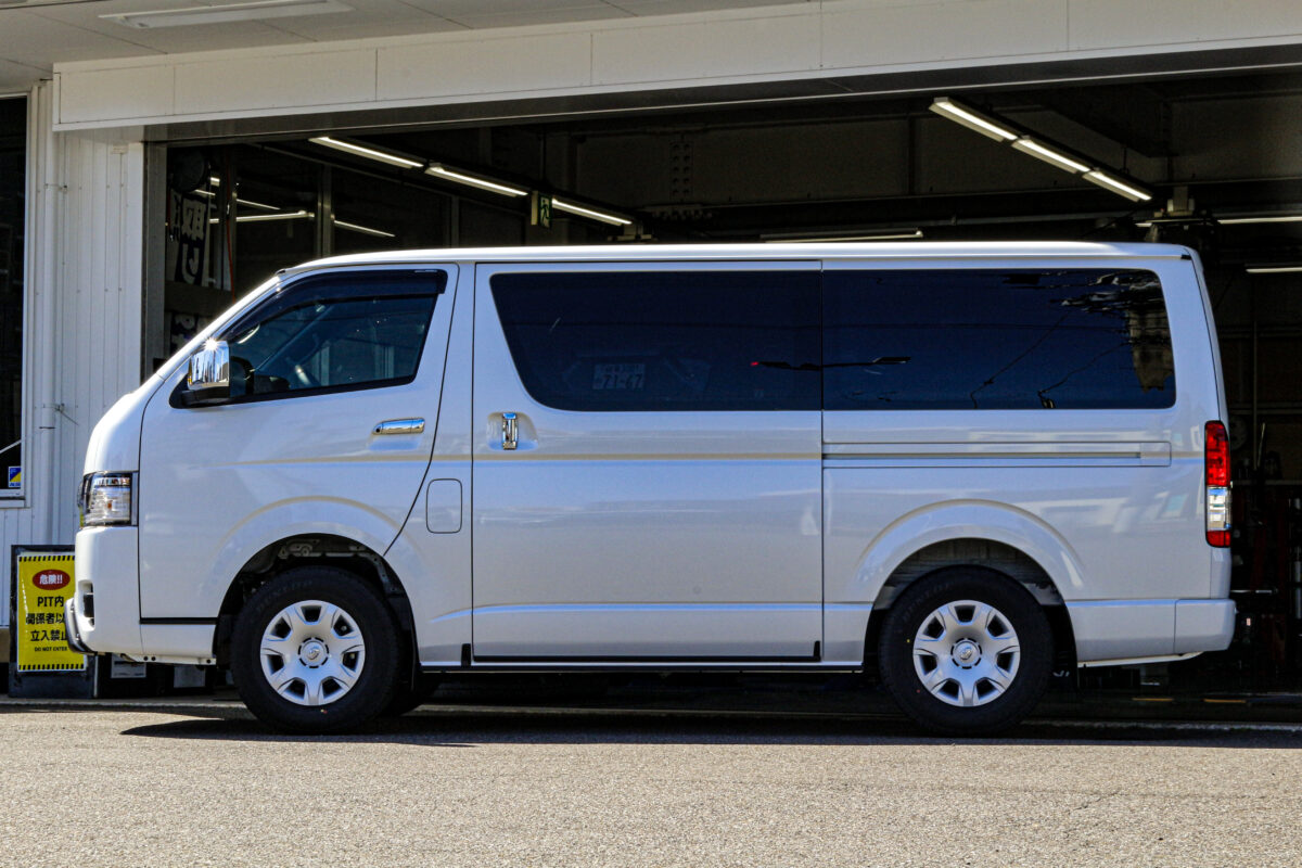 純正タイヤとホイールを装着したカスタム前のトヨタ ハイエースのサイドビュー。ノーマル状態の足回りの印象。