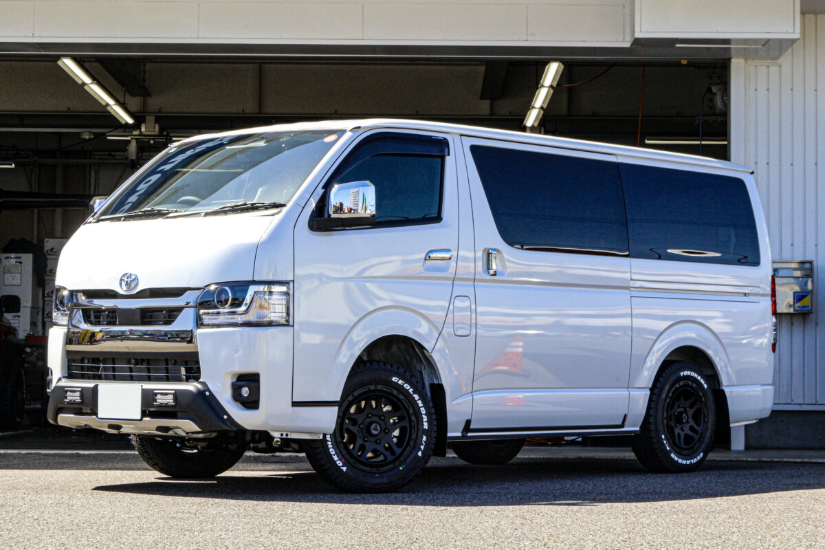 DELTAFORCE OVERLANDERを装着し、足回りの迫力が増したトヨタ ハイエースのフロントビュー。ツインスポークとブロックタイヤがタフさを演出。